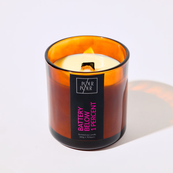 Candle in an amber glass jar with a label on a white background
