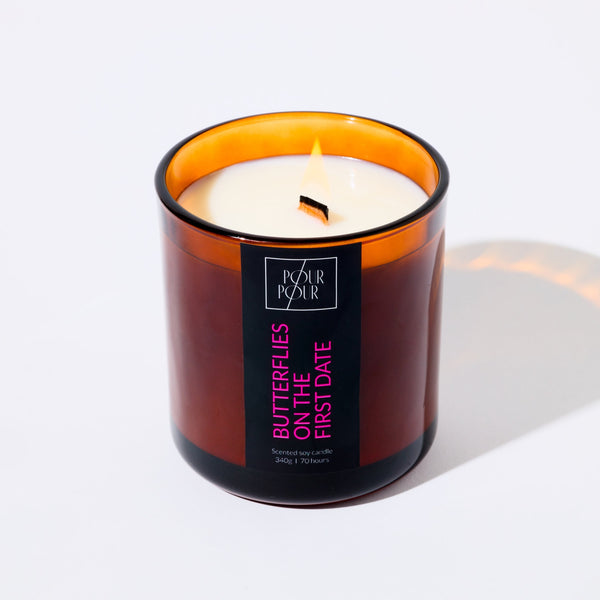 Candle in an amber glass jar with a label on a white background