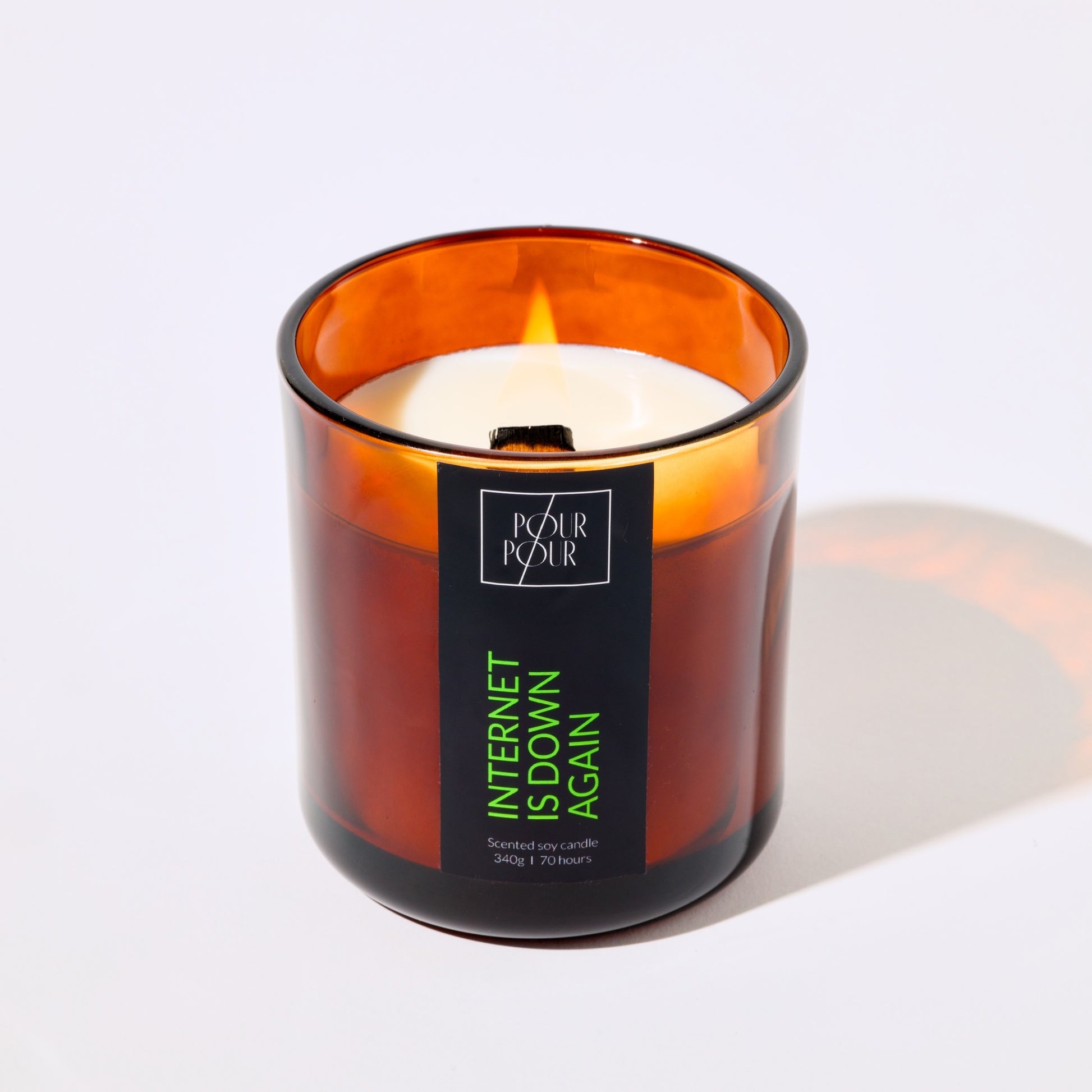 Candle in an amber glass jar with a label on a white background