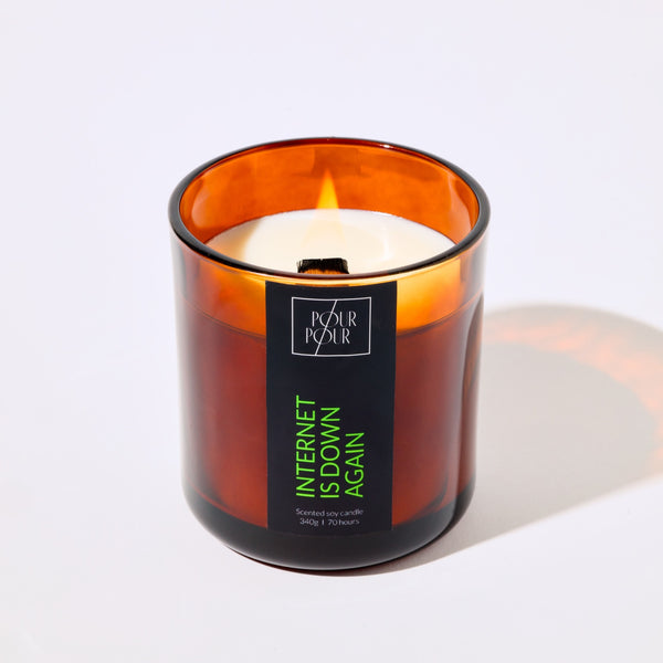 Candle in an amber glass jar with a label on a white background