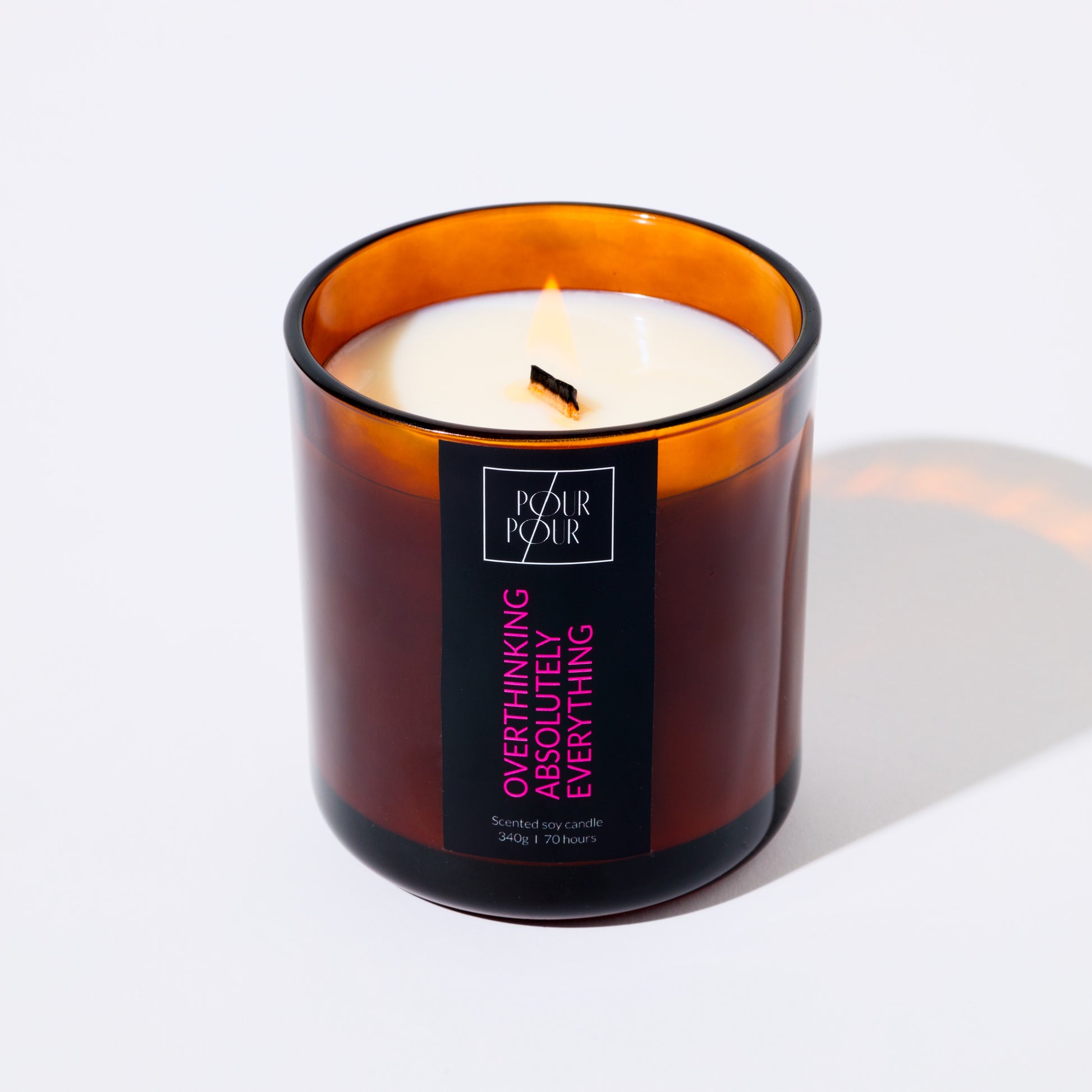 Candle in an amber glass jar with a label on a white background