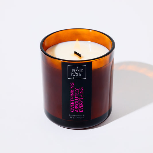 Candle in an amber glass jar with a label on a white background
