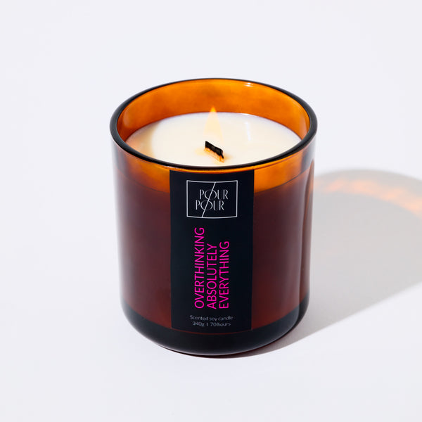 Candle in an amber glass jar with a label on a white background