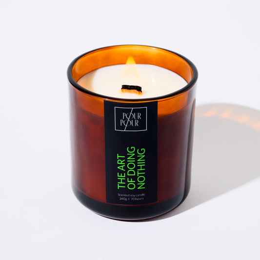 Candle in an amber glass jar with a label on a white background